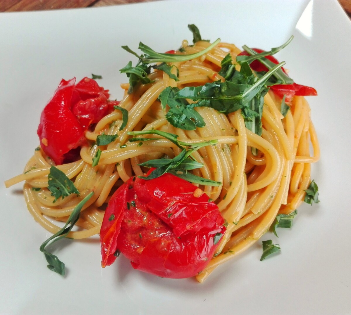 Spaghetti con crema di rucola e stracchino e pomodori al forno
